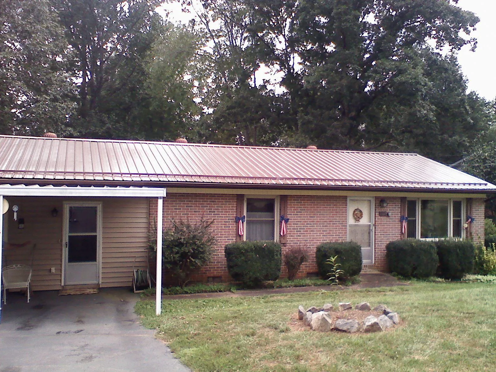 Bronze metal roof and carport on a brick ranch home — Roof Repair work by our crew in Sidney